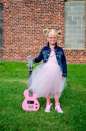 Young girl wearing tutu and denim jacket, holding guitar Stock Photo - Premium Royalty-Free, Code: 614-08081346