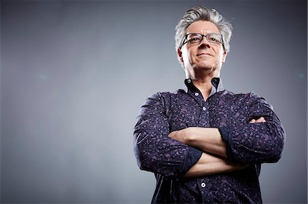 portrait - Low angle studio portrait of mature businessman with arms folded Photographie de stock - Premium Libres de Droits, Code: 614-08081353