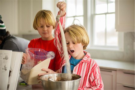 flour - Brothers pouring flour into mixing bowl in kitchen Stock Photo - Premium Royalty-Free, Code: 614-08081387