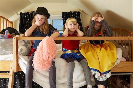 simsearch:614-03469543,k - Three sisters, sitting on bed,  wearing fancy dress costumes, covering mouth, ears and eyes Stock Photo - Premium Royalty-Free, Code: 614-08119504