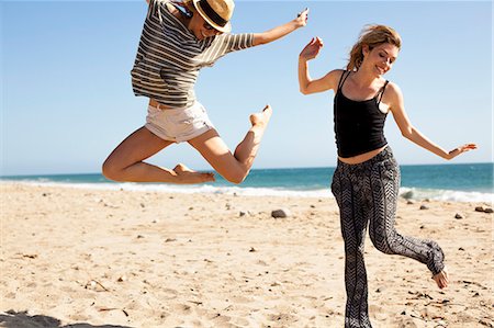 simsearch:614-08119553,k - Girlfriends jumping in mid air on beach, Malibu, California, USA Stock Photo - Premium Royalty-Free, Code: 614-08119558
