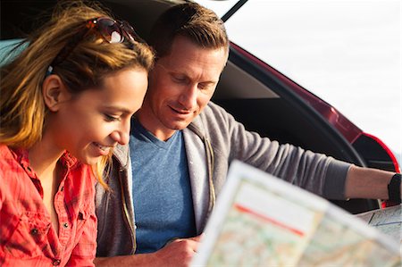 simsearch:614-08119553,k - Couple reading map behind vehicle Stock Photo - Premium Royalty-Free, Code: 614-08119597