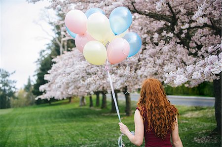 simsearch:649-07437432,k - Rear view of young woman with long wavy red hair and bunch of balloons in spring park Stock Photo - Premium Royalty-Free, Code: 614-08119768