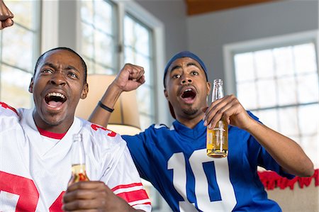 excited african american person - Two male friends celebrating whilst watching TV from sofa Stock Photo - Premium Royalty-Free, Code: 614-08126619