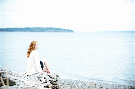 simsearch:614-06897927,k - Young woman sitting on beach looking out to sea, Bainbridge Island, Washington State, USA Foto de stock - Sin royalties Premium, Código: 614-08126676
