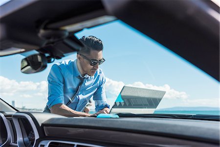 Young businessman at coast parking lot using laptop on car hood Stock Photo - Premium Royalty-Free, Code: 614-08126813