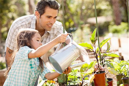 Girl with father using watering can in community garden Stock Photo - Premium Royalty-Free, Code: 614-08148602