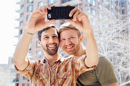 simsearch:614-08148673,k - Male couple standing on balcony, taking self portrait, using smartphone Stock Photo - Premium Royalty-Free, Code: 614-08148685