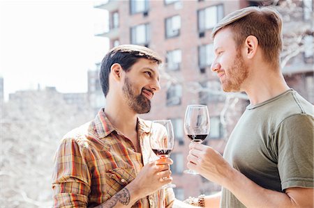 simsearch:614-02613435,k - Male couple standing on balcony, holding wine glasses, face to face Stock Photo - Premium Royalty-Free, Code: 614-08148683