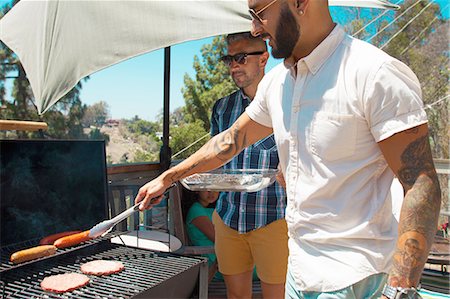 people at barbecue - Two mid adult brothers barbecuing in garden Stock Photo - Premium Royalty-Free, Code: 614-08202001
