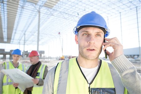 Surveyor talking on smartphone on construction site Stock Photo - Premium Royalty-Free, Code: 614-08202153