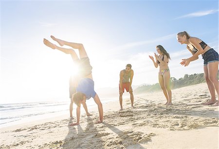 santa monica - Group of friends on beach watching friend do handstand Stock Photo - Premium Royalty-Free, Code: 614-08202260