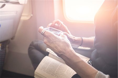 Person playing game on smartphone on board airplane Stock Photo - Premium Royalty-Free, Code: 614-08219901