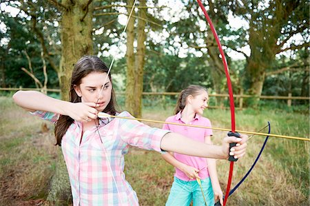 simsearch:614-08270379,k - Girl and teenage sister practicing archery Stock Photo - Premium Royalty-Free, Code: 614-08270386