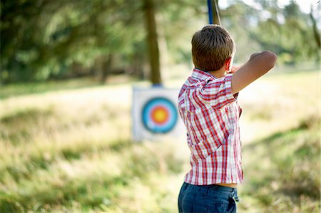 simsearch:614-08270379,k - Rear view of teenage boy practicing archery with target Stock Photo - Premium Royalty-Free, Code: 614-08270392
