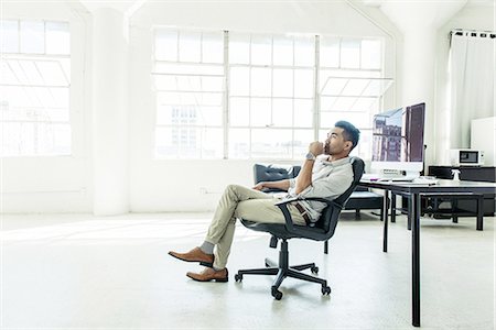 Businessman contemplating by office window Stock Photo - Premium Royalty-Free, Code: 614-08307800