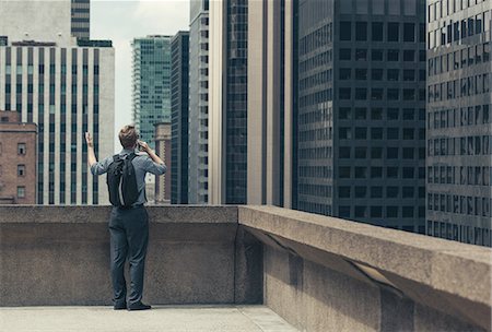 Businessman on rooftop talking on smartphone, Los Angeles, USA Stock Photo - Premium Royalty-Free, Code: 614-08307875