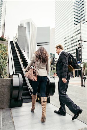 Businesswoman and man walking toward escalator, Los Angeles, USA Stock Photo - Premium Royalty-Free, Code: 614-08307888
