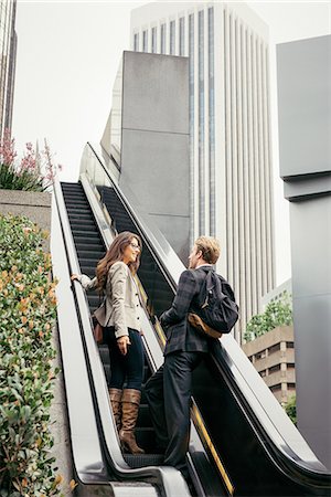 Businesswoman and man moving up escalator, Los Angeles, USA Stock Photo - Premium Royalty-Free, Code: 614-08307889
