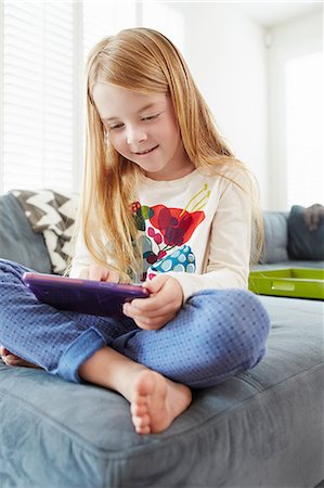 simsearch:649-07280729,k - Girl using digital tablet on sofa in living room Stock Photo - Premium Royalty-Free, Code: 614-08307979