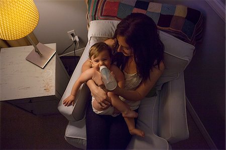 High angle view of mother in armchair feeding baby boy from baby bottle Stock Photo - Premium Royalty-Free, Code: 614-08308000