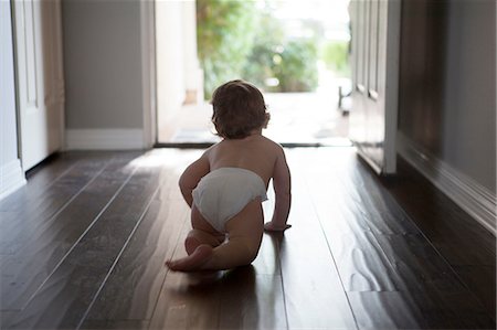 Rear view of baby boy wearing nappy crawling towards open front door Stock Photo - Premium Royalty-Free, Code: 614-08308001