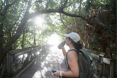 simsearch:632-05604251,k - Female hiker drinking from water bottle on sunlit footbridge, North Palm Beach, Florida, USA Photographie de stock - Premium Libres de Droits, Code: 614-08329335