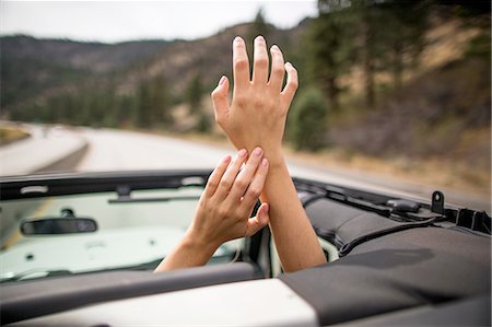 simsearch:649-07280823,k - On the road view of young womans hands raised through jeep sunroof Stock Photo - Premium Royalty-Free, Code: 614-08329407