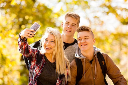simsearch:649-07804673,k - Young woman taking selfie with two teenage brothers in autumn forest Photographie de stock - Premium Libres de Droits, Code: 614-08329533