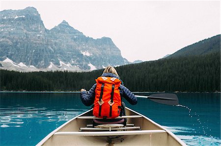 Rear view of mid adult woman paddling canoe, Moraine lake, Banff National Park, Alberta Canada Photographie de stock - Premium Libres de Droits, Code: 614-08383505