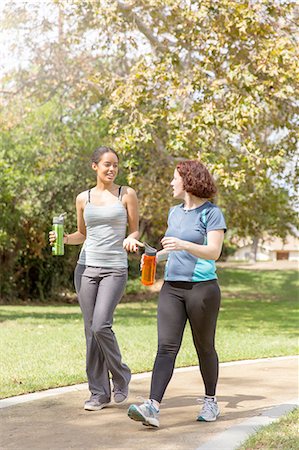 Young women out walking wearing sports clothing carrying water bottles talking Stock Photo - Premium Royalty-Free, Code: 614-08383562