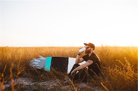 Male surfer drinking coffee in field of long grass at sunset, San Luis Obispo, California, USA Photographie de stock - Premium Libres de Droits, Code: 614-08383697