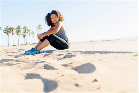 simsearch:614-08392638,k - Mid adult woman sitting on beach, holding water bottle Stock Photo - Premium Royalty-Free, Code: 614-08392511