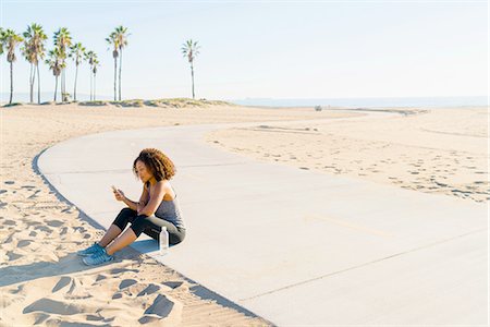 simsearch:614-08392638,k - Mid adult woman sitting by beach, using smartphone Stock Photo - Premium Royalty-Free, Code: 614-08392512