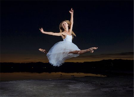 Young female ballet dancer poised leaping over Bonneville Salt Flats at night, Utah, USA Photographie de stock - Premium Libres de Droits, Code: 614-08392716