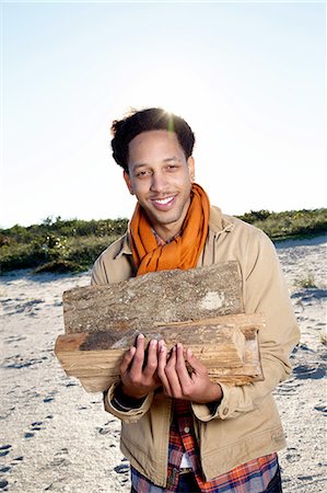 drift wood - Portrait of young man on beach, holding fire wood, smiling Stock Photo - Premium Royalty-Free, Code: 614-08487948