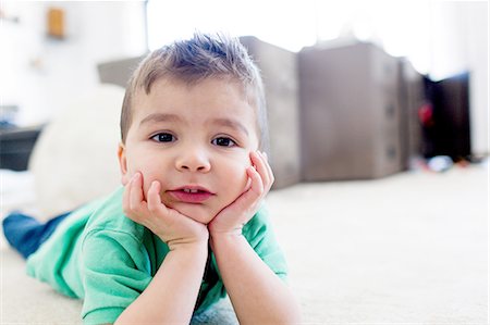 simsearch:649-09078617,k - Preschool boy lying on carpet chin in hands, resting on elbows, looking at camera Stock Photo - Premium Royalty-Free, Code: 614-08487966