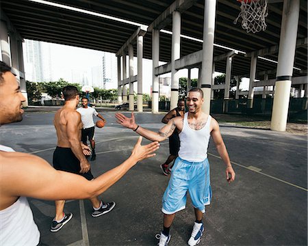 Young men on basketball court connecting with handshake after basketball game smiling Stock Photo - Premium Royalty-Free, Code: 614-08535668