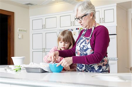 Girl and grandmother mixing cake at kitchen counter Stock Photo - Premium Royalty-Free, Code: 614-08535826