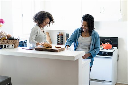 Lesbian couple in kitchen, making breakfast Foto de stock - Sin royalties Premium, Código: 614-08535838