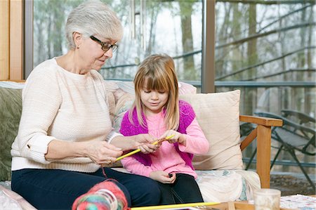 simsearch:649-03858052,k - Senior woman teaching granddaughter knitting on living room sofa Stock Photo - Premium Royalty-Free, Code: 614-08535830