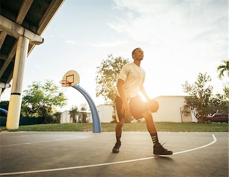 Men on basketball court holding basketball looking away Stock Photo - Premium Royalty-Free, Code: 614-08544697