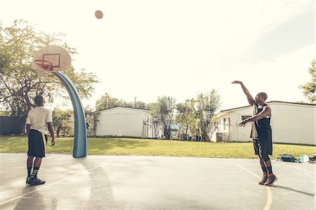 Men on basketball court scoring basketball hoops Stock Photo - Premium Royalty-Free, Code: 614-08544710