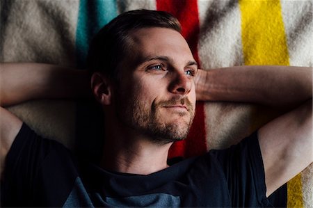 simsearch:614-08392638,k - Overhead portrait of handsome man lying on striped blanket with hands behind head Foto de stock - Sin royalties Premium, Código: 614-08544956