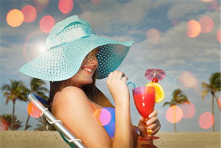 Young woman sitting on deckchair with cocktail at Miami beach, Florida, USA Stock Photo - Premium Royalty-Free, Code: 614-08578270