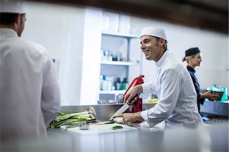 Chefs chatting and preparing food in kitchen Stock Photo - Premium Royalty-Free, Code: 614-08578565