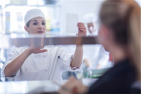Chef taking orders from waitress in kitchen Photographie de stock - Premium Libres de Droits, Code: 614-08578575