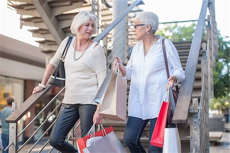 Mature women shoppers moving down shopping mall stairway Stock Photo - Premium Royalty-Free, Code: 614-08578600