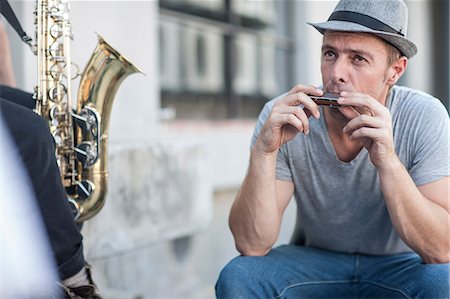 Street musician playing harmonica Stock Photo - Premium Royalty-Free, Code: 614-08578647