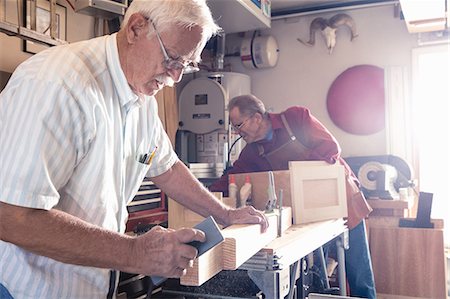 Senior man sanding woodblock in carpentry workshop Stock Photo - Premium Royalty-Free, Code: 614-08578728